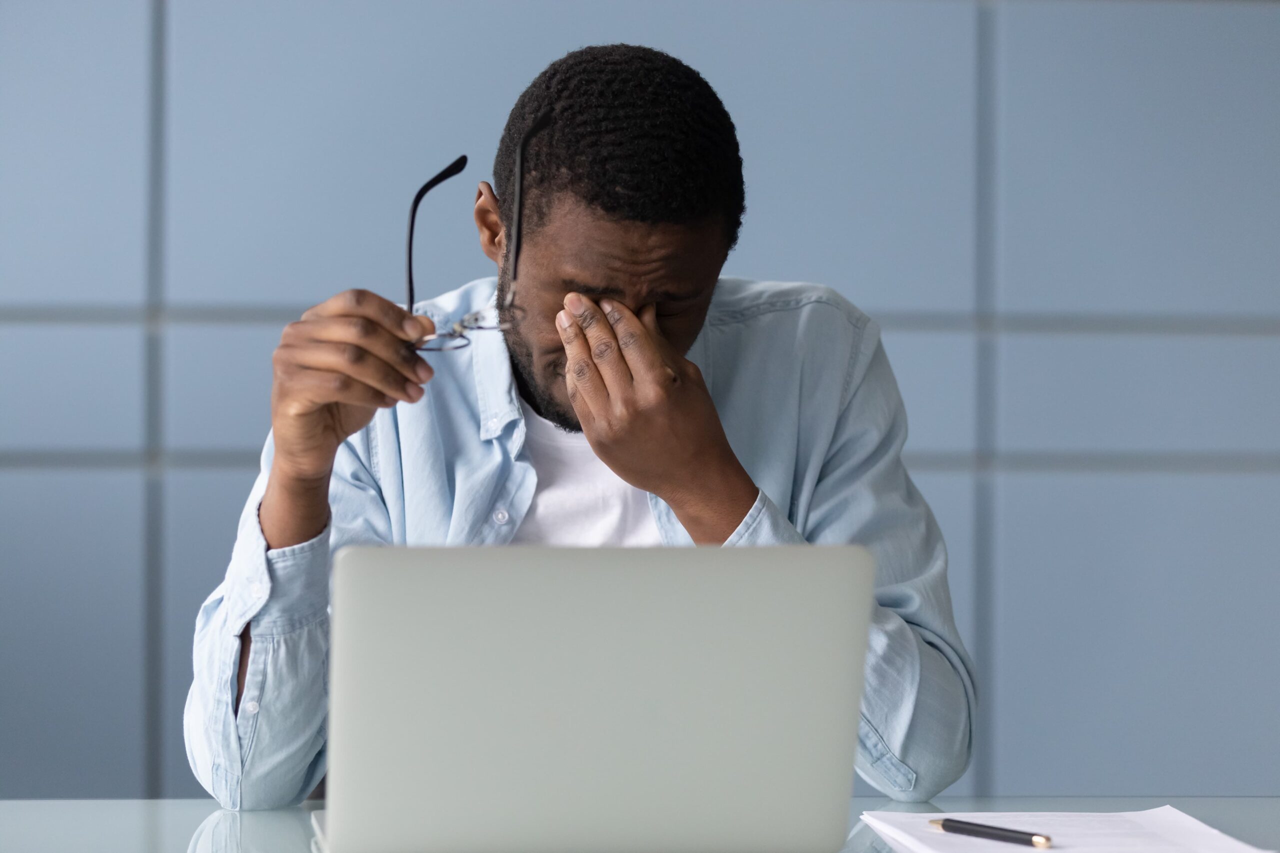 man rubbing his eyes