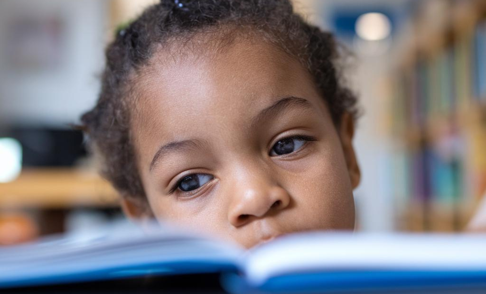 image of a child looking at a page in a book image of a child looking at a page in a book